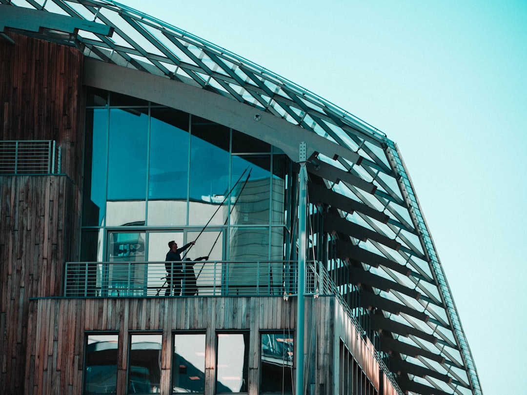 a-man-standing-on-a-balcony-of-a-building-npcikvoa1sy